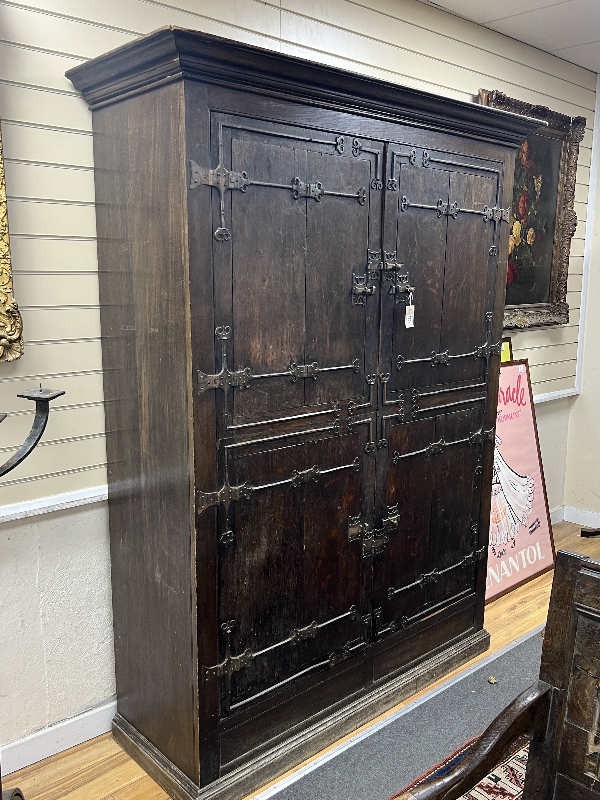 A pair of 16th century German or Netherlandish oak and wrought iron strapwork window shutters, later mounted on a cupboard, width 156cm, depth 57cm, height 210cm